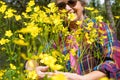 Smiling blurred woman hugs a group of yellow flowers in the meadow Royalty Free Stock Photo