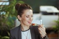 smiling bookkeeper woman in green office eating salad