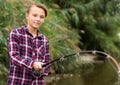 Smiling boy casting line for fishing on lake Royalty Free Stock Photo