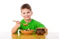 Smiling boy eating oatmeal at the table Royalty Free Stock Photo