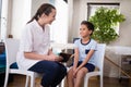 Smiling boy and female therapist sitting with digital tablet Royalty Free Stock Photo