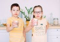 Smiling boy and girl hold glasses of clean water in hands, selective focus Royalty Free Stock Photo