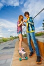 Smiling boy and girl on skateboard hold hands