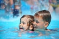 Smiling boy and girl swimming in pool in aquapark Royalty Free Stock Photo