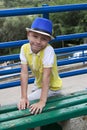 smiling boy in hat sitting on a bench Royalty Free Stock Photo