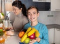 Mother and son in the kitchen preparing fresh orange juice Royalty Free Stock Photo