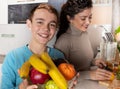 Mother and son in the kitchen preparing fresh orange juice Royalty Free Stock Photo