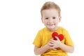 Smiling boy holding a red heart figurine. symbol of love, family, . Concept of the family and children. Royalty Free Stock Photo