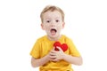 Smiling boy holding a red heart figurine. symbol of love, family, . Concept of the family and children. Royalty Free Stock Photo