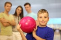 Smiling boy holds ball in bowling club Royalty Free Stock Photo