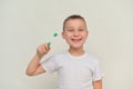 a smiling boy holds a toothbrush in his hand. mock up