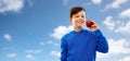 Smiling boy in hoodie with red apple over blue sky Royalty Free Stock Photo