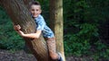 Smiling boy hugs a tree trunk Royalty Free Stock Photo