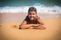 Smiling boy lying on the beach, outdoors Royalty Free Stock Photo