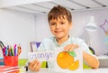 Smiling boy with orange word and card at class Royalty Free Stock Photo