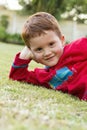 Smiling boy outsise on lawn