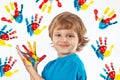 Smiling boy with painted hands on background of hand prints Royalty Free Stock Photo