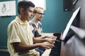 Smiling boy playing the piano with his teacher Royalty Free Stock Photo