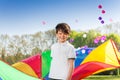 Smiling boy playing rainbow parachute in the park