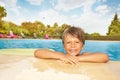 Smiling boy relaxing near edge of swimming pool Royalty Free Stock Photo