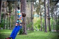 Smiling boy rides a zip line. happy child on the zip line. The kid passes the rope obstacle course