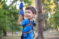 Smiling boy rides a zip line. happy child on the zip line. The kid passes the rope obstacle course