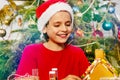 Smiling boy in Santa hat play with gingerbread house