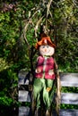 Smiling boy scarecrow leaning against a wood fence, cheerful fall celebration for Halloween and Thanksgiving Royalty Free Stock Photo