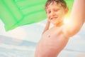 Smiling boy sea portrait with green air swiming mattress