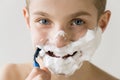 Smiling Boy Shaving Face with Plastic Razor