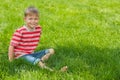 Smiling boy sits on the green grass Royalty Free Stock Photo