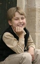 Smiling boy sitting on doorstep Royalty Free Stock Photo