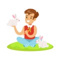 Smiling boy sitting on green grass, playing and feeding two white rabbits with carrot. Colorful cartoon character vector Royalty Free Stock Photo