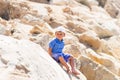 Smiling boy sitting on the rock.