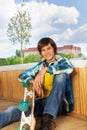 Smiling boy with skateboard sitting alone Royalty Free Stock Photo