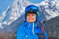 Smiling boy in ski gear stand over Alps mountains peaks Royalty Free Stock Photo