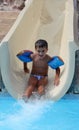 Smiling boy slides a waterslide Royalty Free Stock Photo