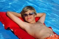 Smiling boy with sun glasses relaxing on airbed Royalty Free Stock Photo