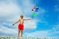 Smiling boy in sunglasses stand with many kites on pebble beach Royalty Free Stock Photo