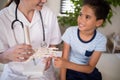 Smiling boy touching artificial bone held by female therapist