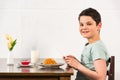 Boy using digital tablet during breakfast in kitchen Royalty Free Stock Photo
