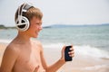 Smiling boy using a smartphone on the beach Royalty Free Stock Photo