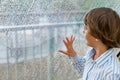 Smiling boy watching the rain outside at a window Royalty Free Stock Photo