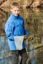 Smiling boy in winter clothes with fishing net Royalty Free Stock Photo