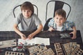 Smiling boys putting heads up while sitting at the table