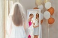 Smiling bride and bride maid looking at mirror.