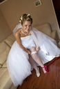 Smiling bride setting the garter Royalty Free Stock Photo