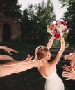 Smiling bride tossing a bouquet for her good friends Royalty Free Stock Photo