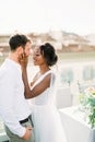 Smiling bride touches groom face with hands on terrace at home Royalty Free Stock Photo