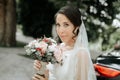 Smiling bride in wedding dress and veil holding bridal bouquet Royalty Free Stock Photo